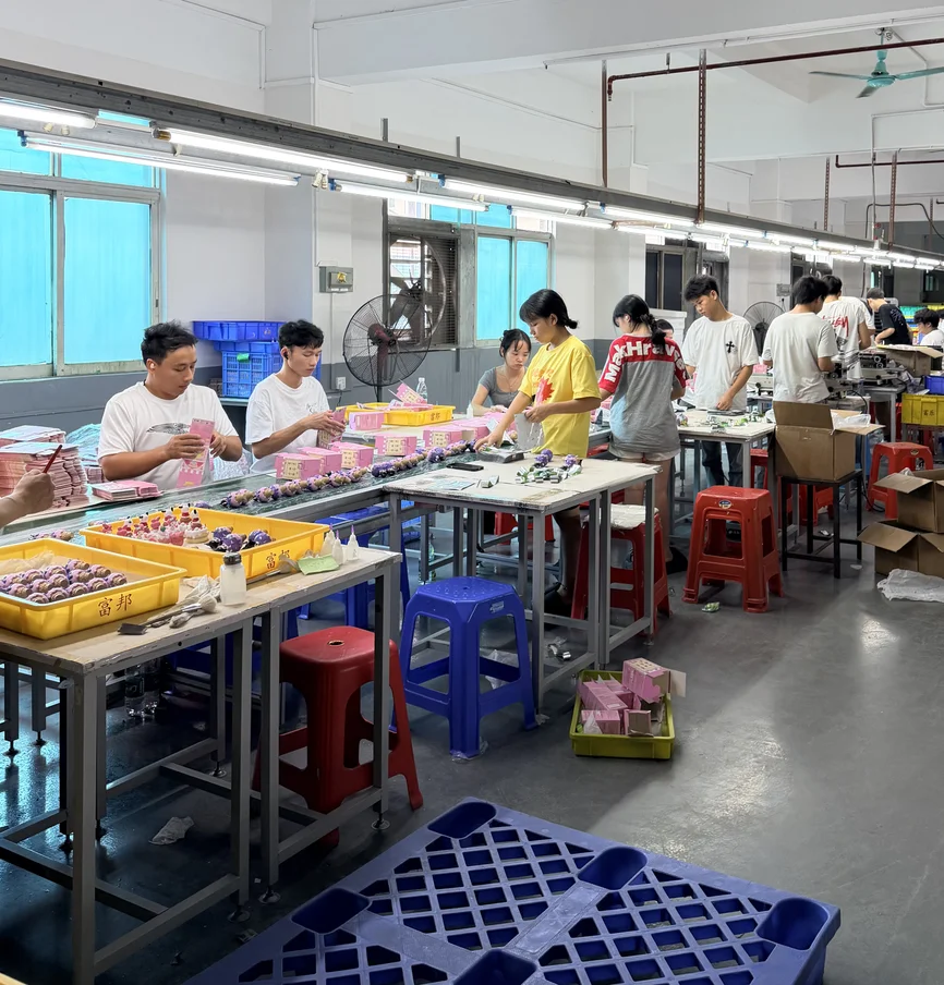 PopZao assembly line with workers packing figures