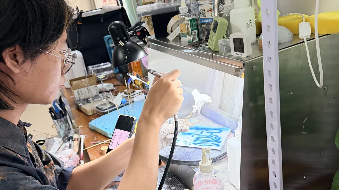 Painter airbrushing the figure